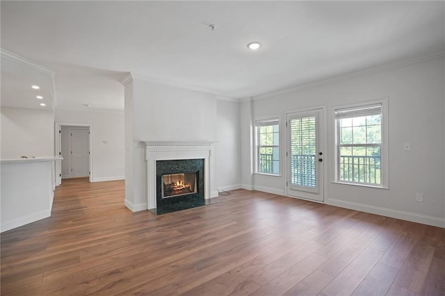 unfurnished living room with hardwood / wood-style floors, ornamental molding, and a fireplace