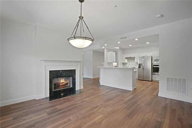 unfurnished living room with a premium fireplace, dark hardwood / wood-style flooring, and ornamental molding