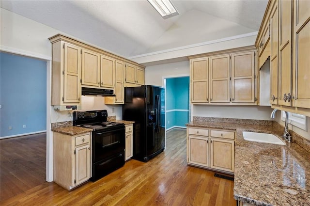 kitchen with light hardwood / wood-style flooring, vaulted ceiling with skylight, black appliances, and sink