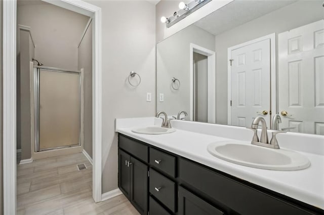 bathroom with vanity, hardwood / wood-style floors, and a shower with door