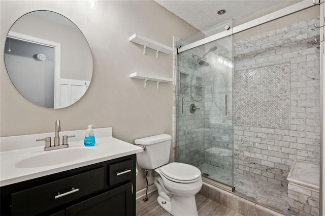 bathroom with hardwood / wood-style flooring, walk in shower, vanity, and toilet