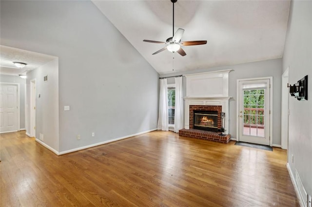 unfurnished living room featuring ceiling fan, a fireplace, hardwood / wood-style floors, and a wealth of natural light