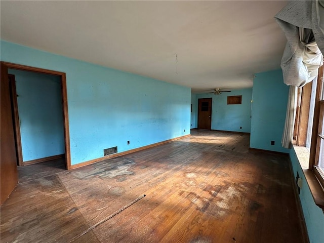 unfurnished living room featuring a ceiling fan, baseboards, visible vents, and hardwood / wood-style floors