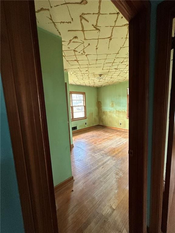 hall featuring baseboards and light wood finished floors