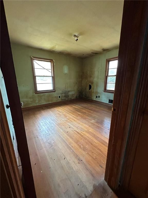 unfurnished room featuring visible vents and hardwood / wood-style floors