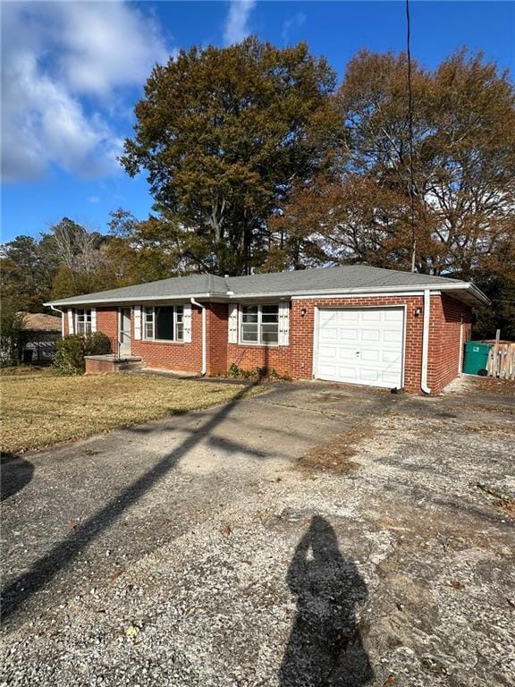 ranch-style home with driveway, a garage, and brick siding