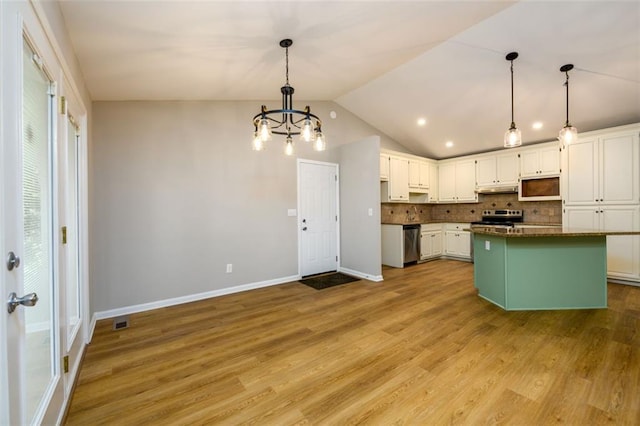 3105 The Trail Rd, Gainesville, GA 30501 - kitchen with stainless steel appliances, white cabinetry, backsplash, under cabinet range hood, and vaulted ceiling