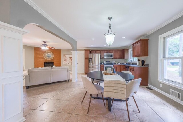 2279 Parkview Cir, College Park, GA 30337 - dining space with a fireplace, a ceiling fan, light tile patterned floors, crown molding, and ornate columns