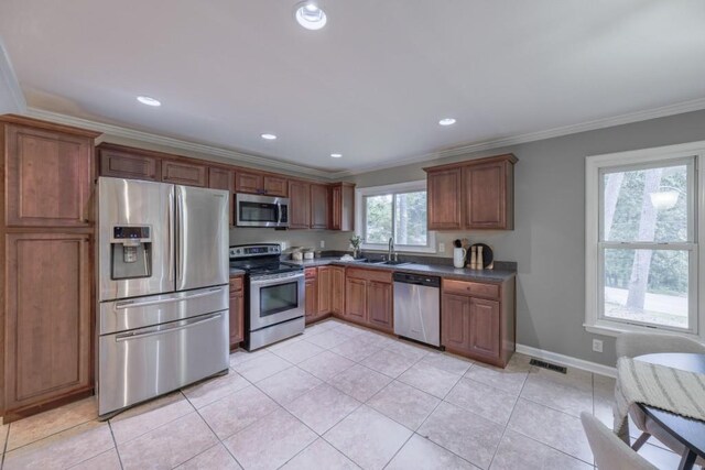 2279 Parkview Cir, College Park, GA 30337 - kitchen with appliances with stainless steel finishes, ornamental molding, a sink, dark countertops, and light tile patterned floors