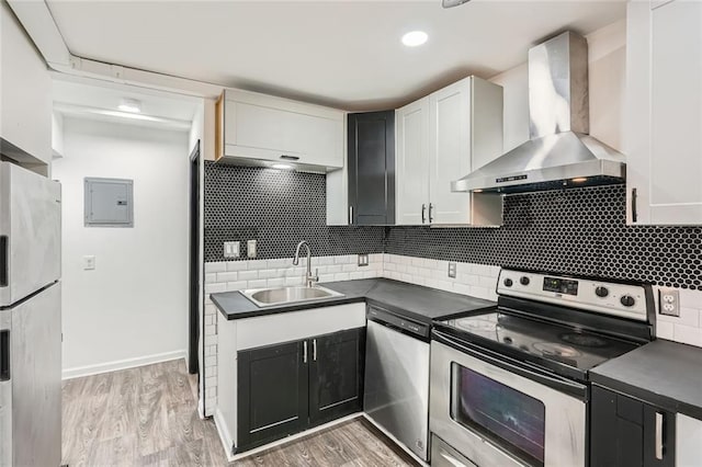 kitchen with white cabinetry, wall chimney range hood, stainless steel appliances, sink, and electric panel