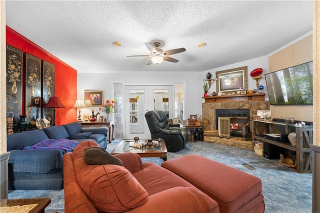 carpeted living room featuring french doors, ceiling fan, a fireplace, and a textured ceiling