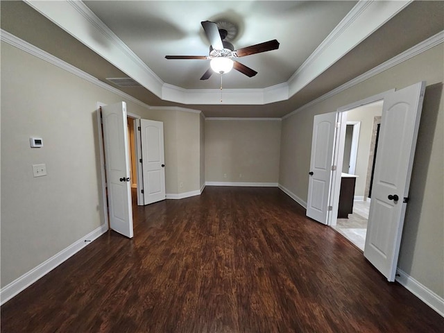 unfurnished bedroom with a tray ceiling, ornamental molding, dark hardwood / wood-style floors, and ceiling fan