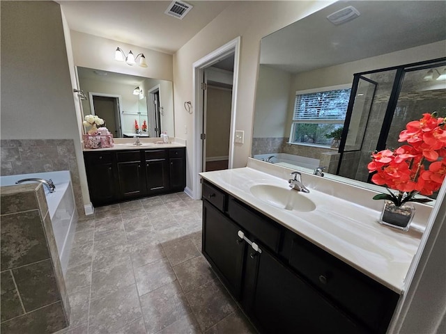 bathroom with vanity and shower with separate bathtub