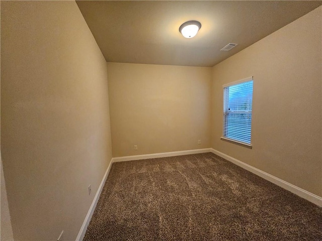 spare room with dark carpet