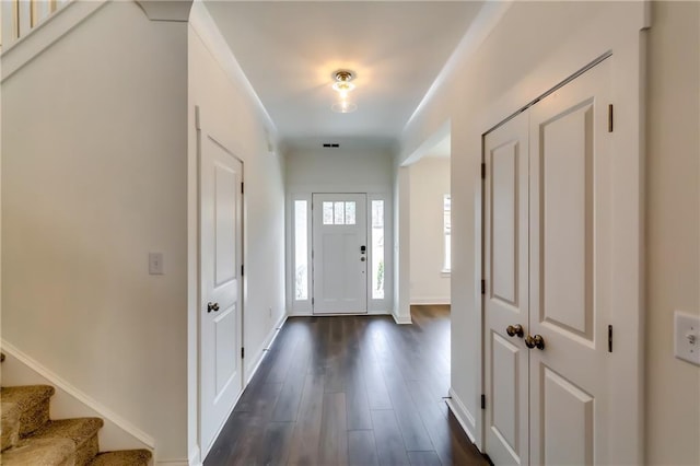 foyer entrance with stairway, baseboards, and dark wood-style flooring