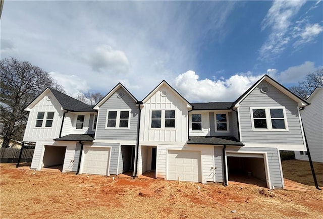 townhome / multi-family property with fence, board and batten siding, and an attached garage