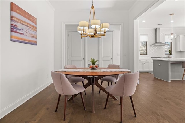 dining space featuring dark wood-type flooring, ornamental molding, and a notable chandelier