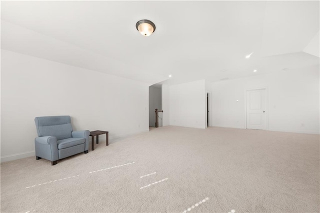 sitting room with lofted ceiling and light carpet