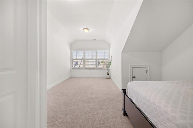 bedroom featuring vaulted ceiling and light carpet