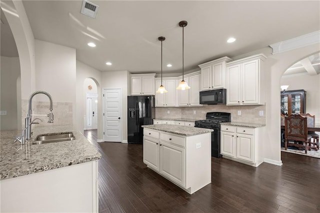 kitchen with white cabinetry, sink, backsplash, pendant lighting, and black appliances