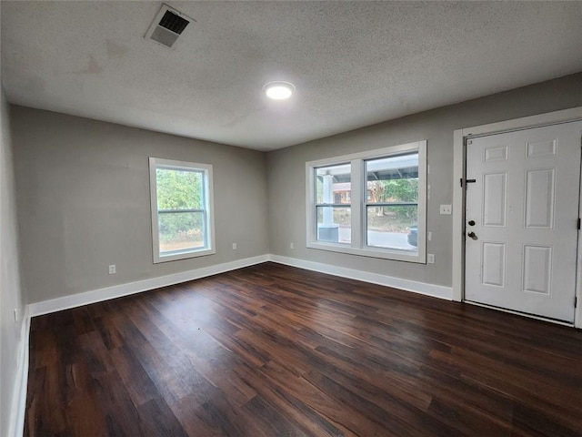 entrance foyer with dark hardwood / wood-style flooring and a textured ceiling