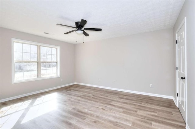 empty room with ceiling fan and light hardwood / wood-style flooring