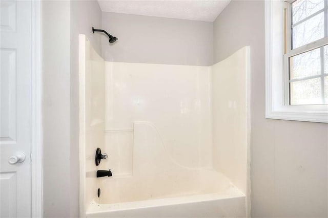 bathroom featuring shower / bath combination and a textured ceiling