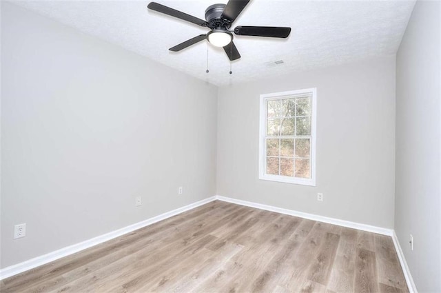 empty room featuring a textured ceiling, light hardwood / wood-style flooring, and ceiling fan