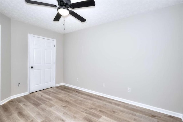 empty room featuring a textured ceiling, light hardwood / wood-style floors, and ceiling fan