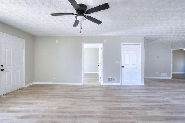 empty room featuring ceiling fan, a textured ceiling, and light wood-type flooring