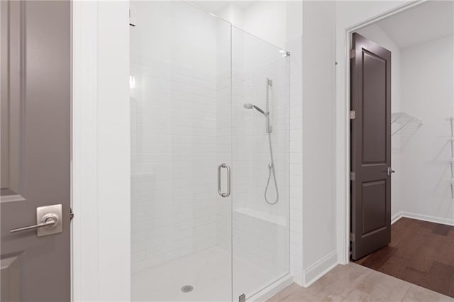 bathroom with a shower with shower door and tile patterned flooring