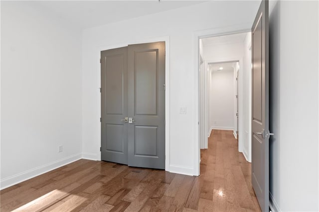 unfurnished bedroom with light hardwood / wood-style floors and a closet