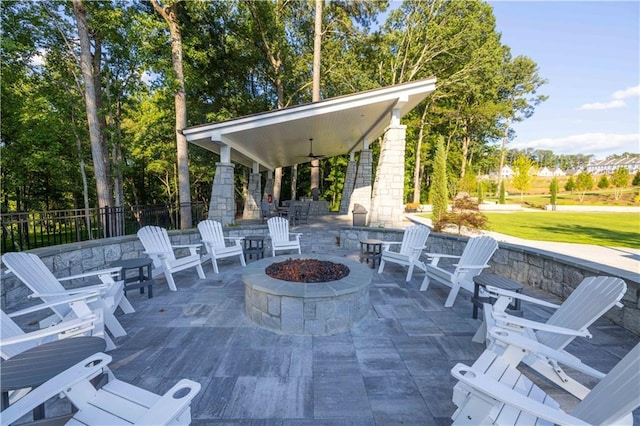 view of patio with ceiling fan and an outdoor fire pit