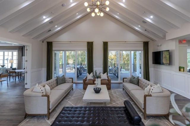 living room featuring dark hardwood / wood-style floors, lofted ceiling with beams, and an inviting chandelier