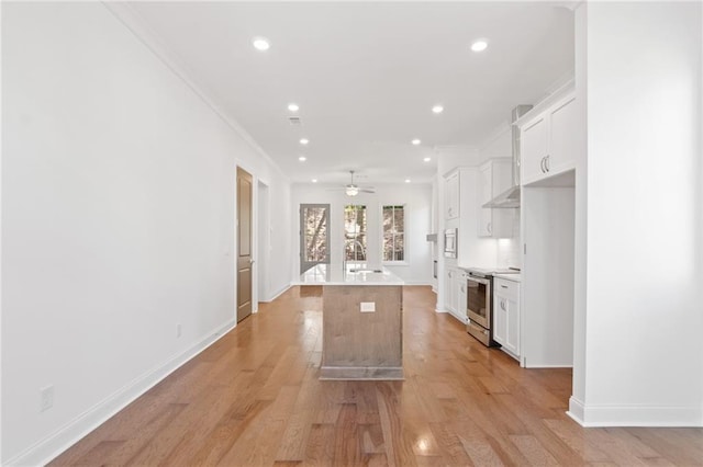 kitchen with backsplash, appliances with stainless steel finishes, white cabinetry, and a center island with sink