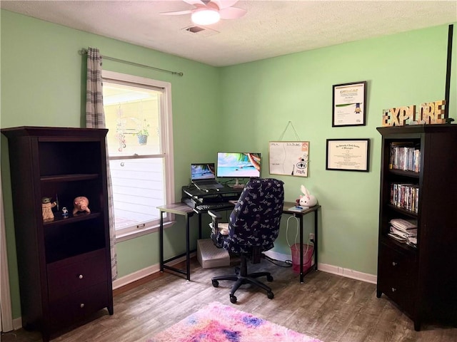 office space with wood finished floors, a ceiling fan, plenty of natural light, and a textured ceiling