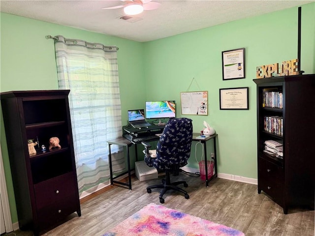 office space with wood finished floors, a ceiling fan, and baseboards