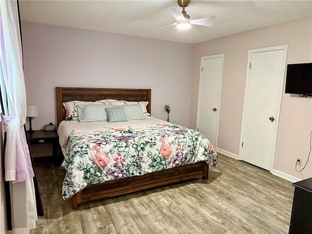 bedroom with light wood-style floors, baseboards, and ceiling fan