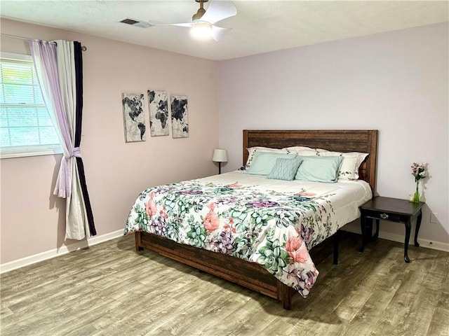 bedroom with wood finished floors, baseboards, and ceiling fan