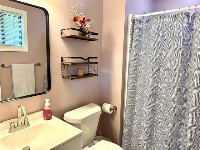 bathroom featuring vanity, toilet, and a shower with curtain