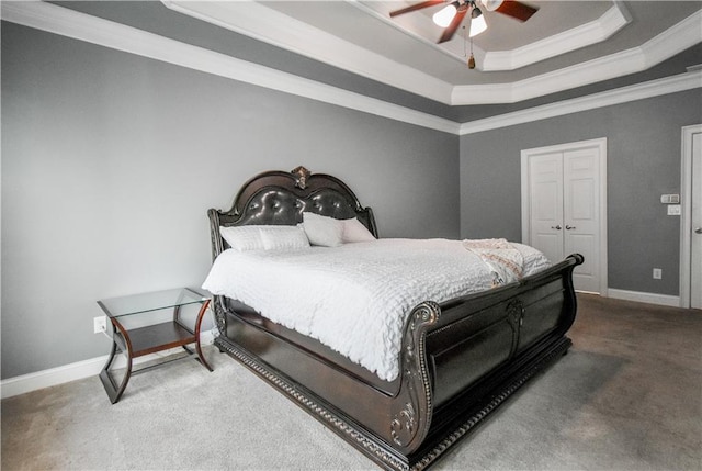 carpeted bedroom featuring a raised ceiling, ornamental molding, and ceiling fan