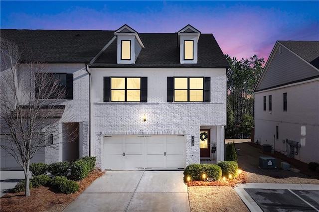 view of front of home with central AC unit and a garage