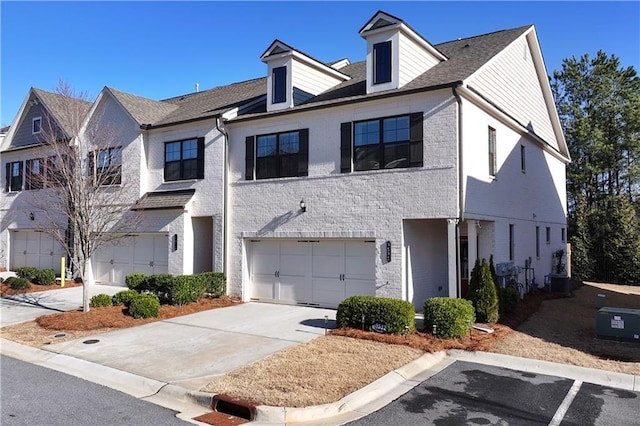 townhome / multi-family property featuring a garage and central air condition unit