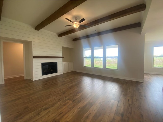 216 Montview Dr, Jefferson, GA 30549 - unfurnished living room with ceiling fan, baseboards, a large fireplace, dark wood finished floors, and beamed ceiling