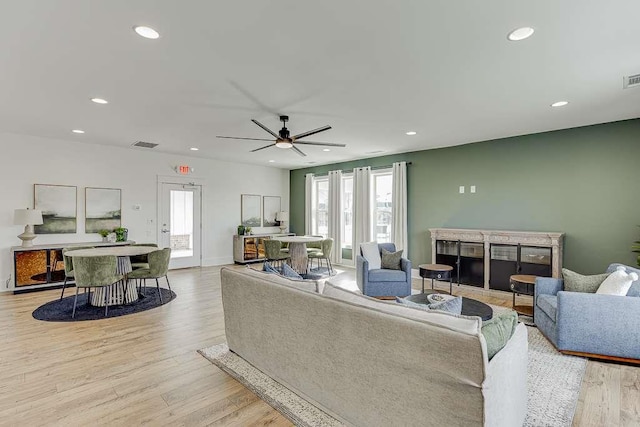 living room featuring light hardwood / wood-style floors and ceiling fan