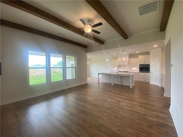 216 Montview Dr, Jefferson, GA 30549 - unfurnished living room featuring beamed ceiling, baseboards, ceiling fan, dark wood-style floors, and a sink