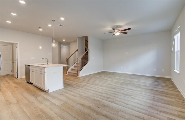 8147 Tiger Way, Riverdale, GA 30296 - kitchen with a sink, a ceiling fan, a kitchen island with sink, light wood finished floors, and dishwasher