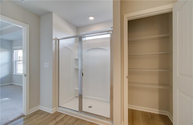 8147 Tiger Way, Riverdale, GA 30296 - bathroom with wood finished floors, a stall shower, baseboards, and a spacious closet