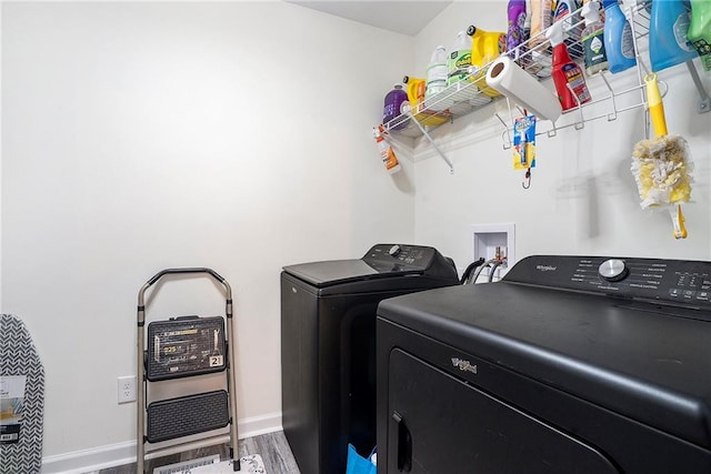 laundry room featuring separate washer and dryer and hardwood / wood-style floors