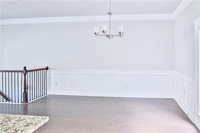 unfurnished dining area featuring ornamental molding, dark hardwood / wood-style floors, and a chandelier